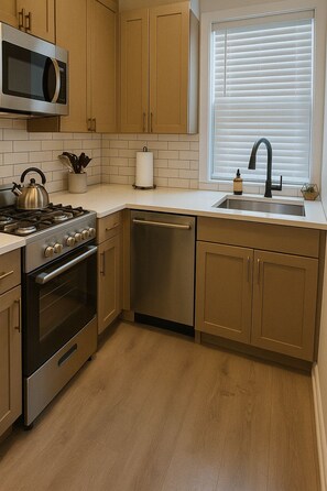 A modern kitchen with stainless steel appliances, wooden cabinets, and a window with blinds. - Cozy 2BR Apt for a Seamless Stay (Chicago)