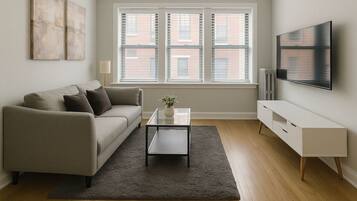 A living room with a sofa, coffee table, and TV.