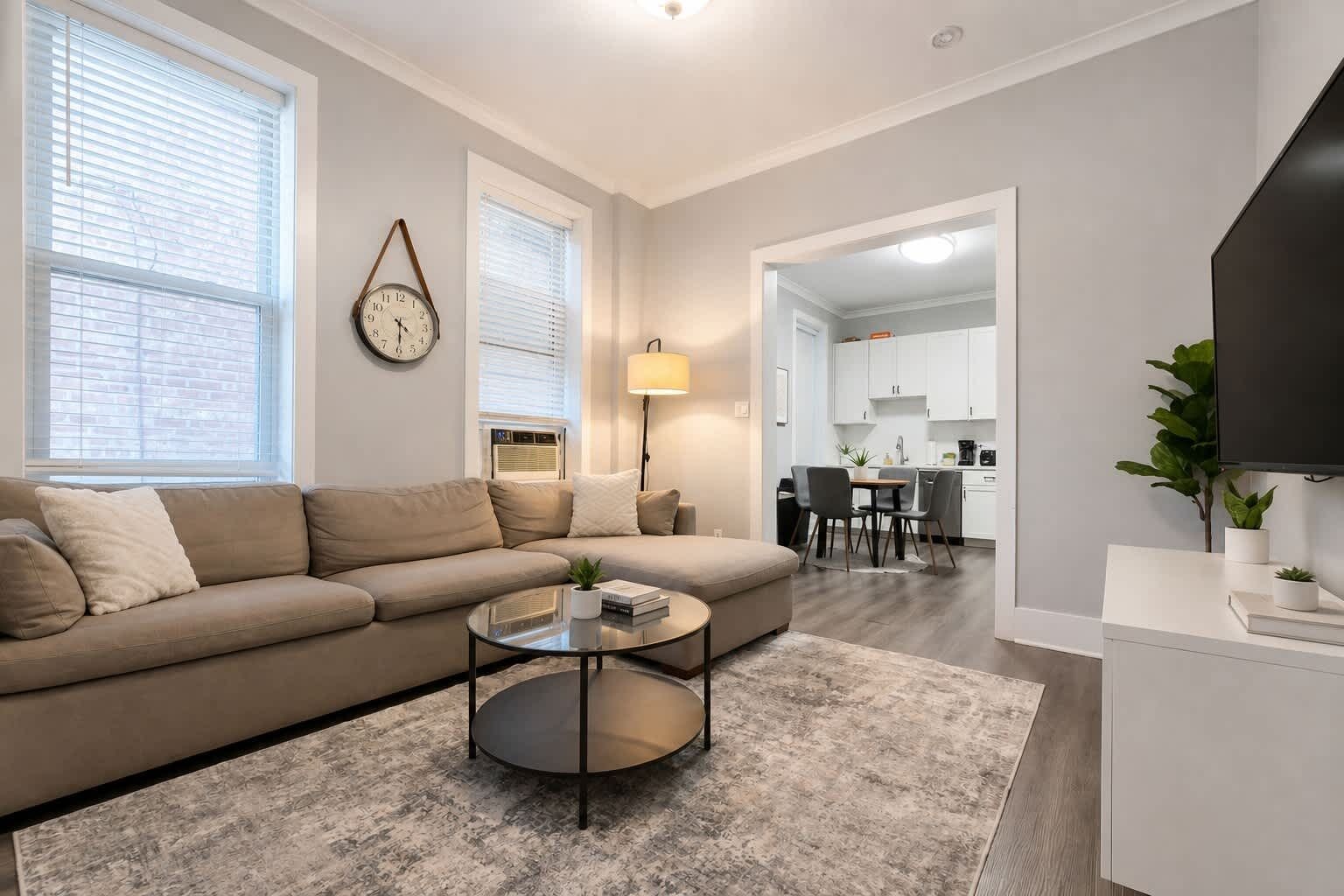 Un salon moderne comprenant un canapé, une table basse et un coin repas avec des chaises et une table.