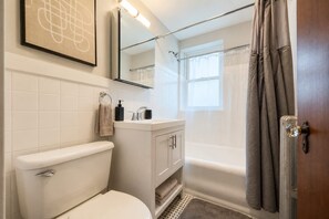 Un baño con inodoro, lavabo y ducha.