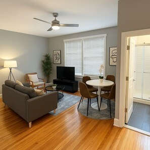 A living room with a sofa, TV, and dining area.