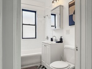 Une salle de bain avec une baignoire, des toilettes et un lavabo.