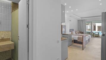 Una habitación de hotel moderna con cama, baño y vistas a una piscina.