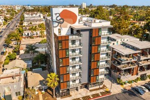 A multi-story building with a modern design, featuring balconies and large windows. - The Ember Retreat !! (San Diego)