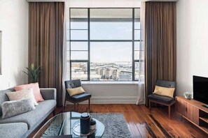 Un salon moderne comprenant un canapé, deux fauteuils, une table basse et un meuble pour la télévision.