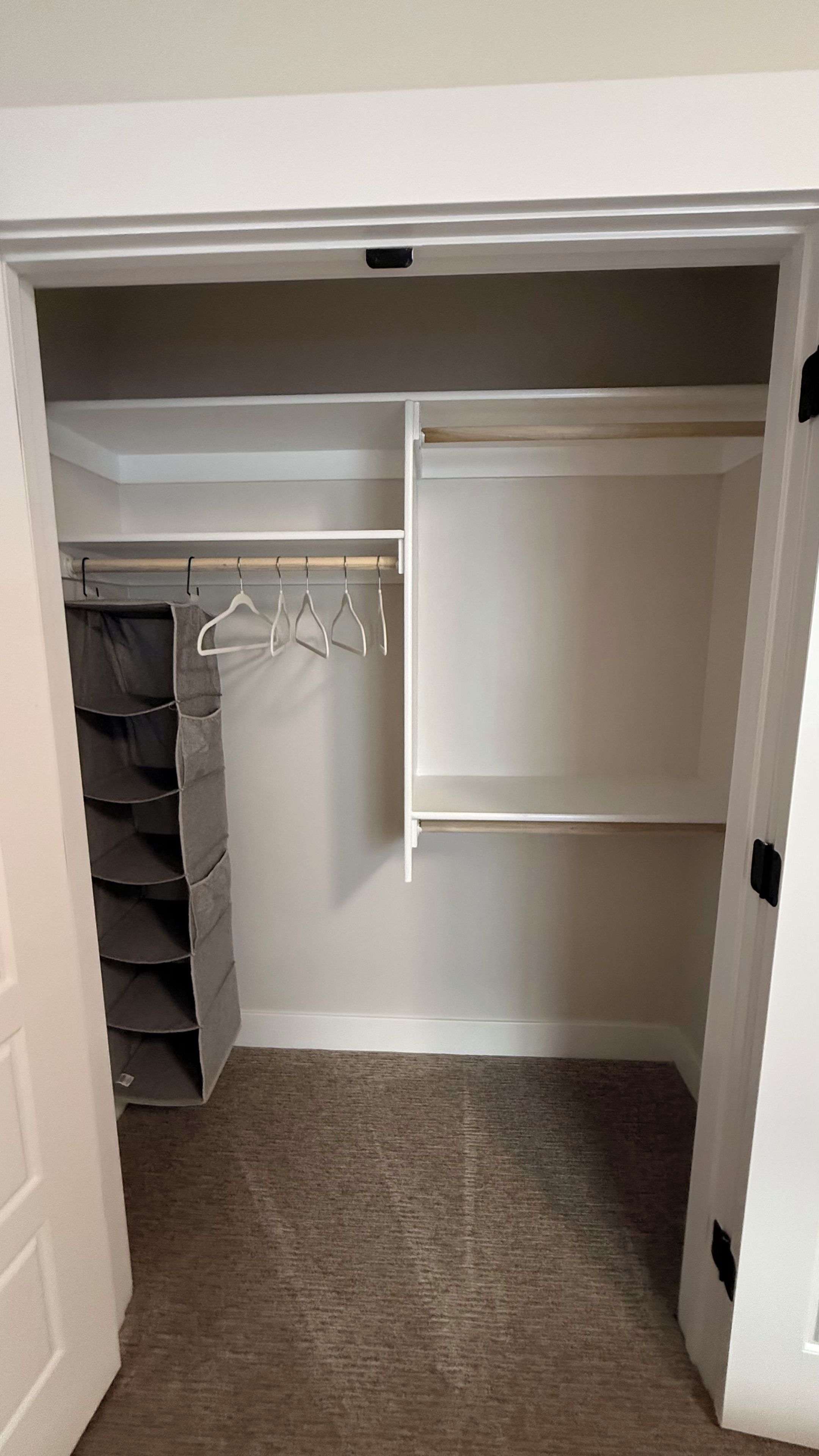 A walk-in closet with a hanging rod and shelves.
