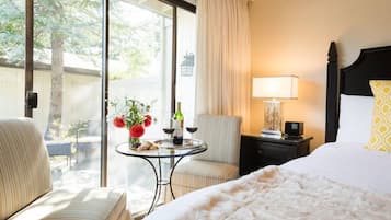 Une chambre d’hôtel dotée d’un grand lit, d’un coin salon avec une table et offrant une vue sur l’extérieur.