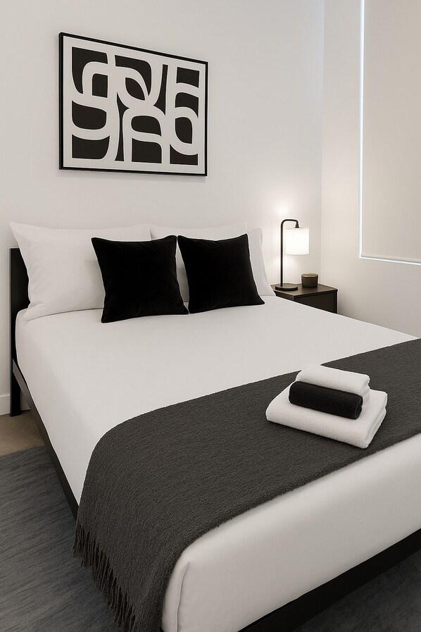 Une chambre d’hôtel avec un lit, une table de chevet, une lampe et une œuvre d’art murale.