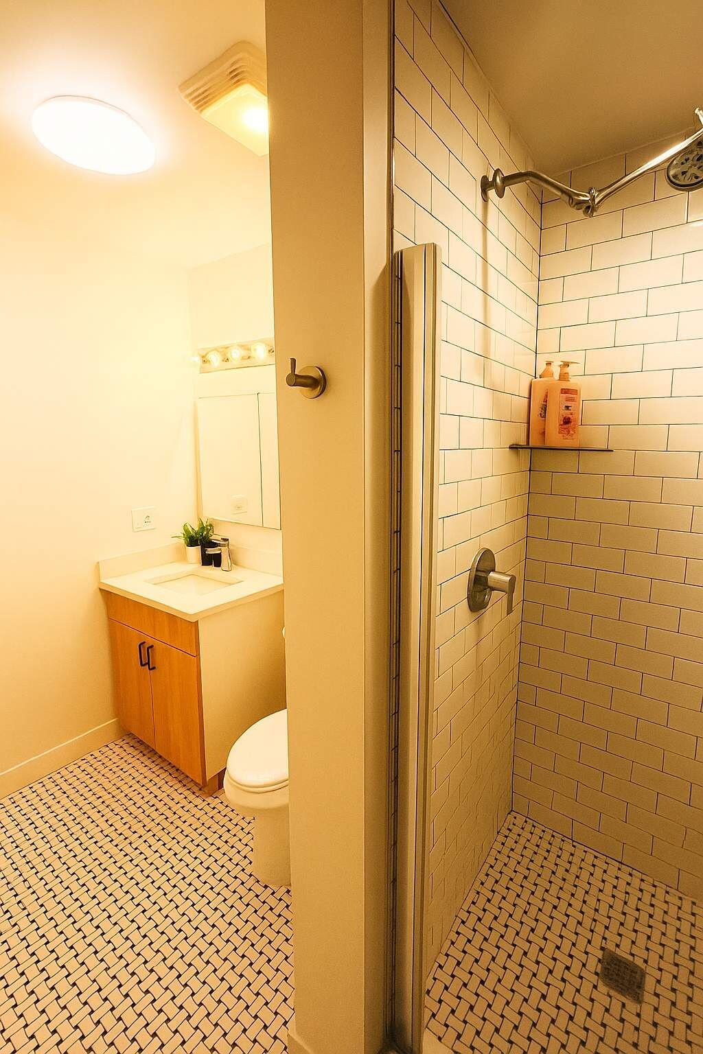Une salle de bain comprenant des toilettes, un lavabo et un espace douche.