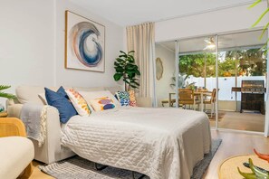 Uma sala de estar moderna com sofá, mesa de centro e área de jantar com cadeiras.