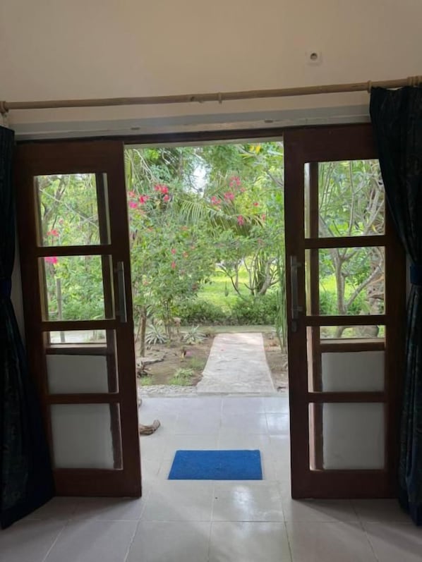 A room with an open door leading to a garden.