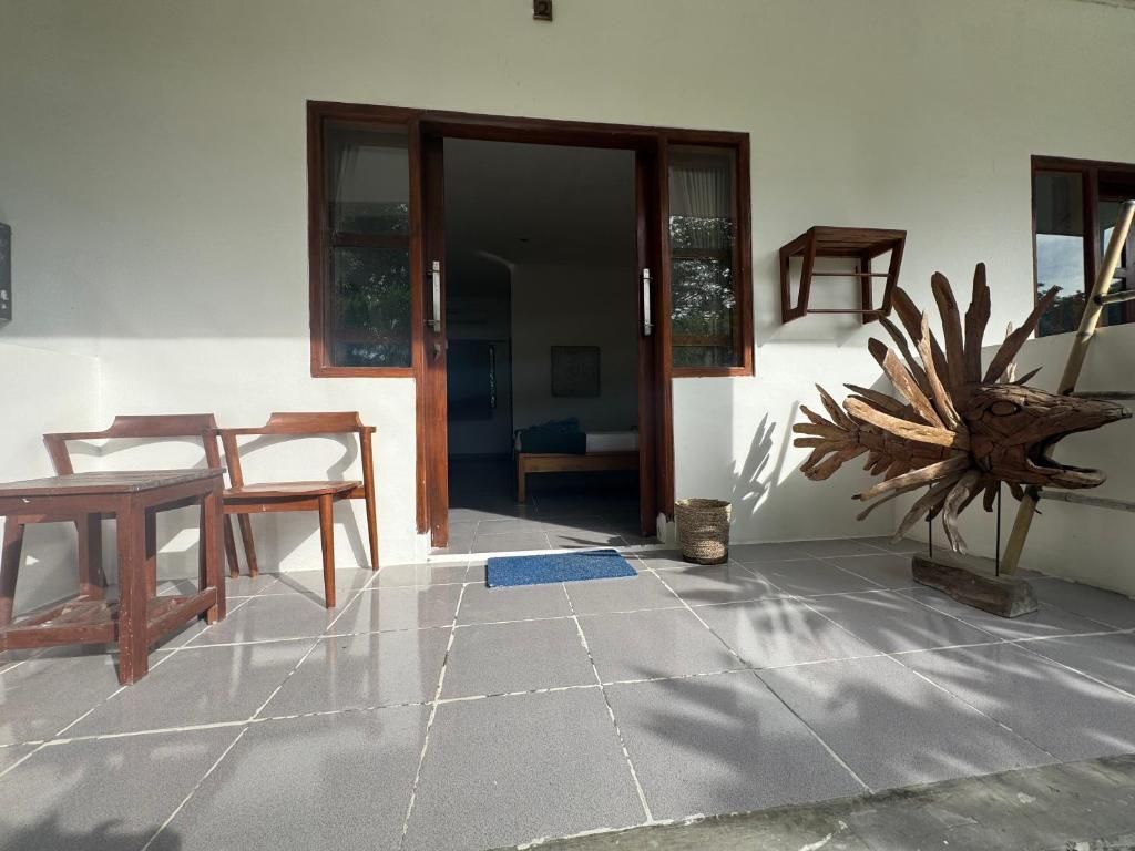A room with a wooden chair, a small table, a large decorative piece, and a sliding door leading to another room.
