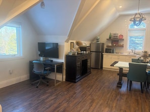 A modern kitchen with a dining area, a TV, and a refrigerator. - Entire Private one Bedroom Apartment Alton, Ont (Caledon)