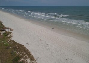 A beach with a wooden walkway leading to a structure, a sandy shore, and the ocean. - Summerhouse 147 2 Bedroom Condo (St. Augustine)