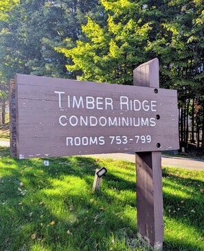 Een houten bordje voor Condominiums Timber Ridge met een telefoonnummer.