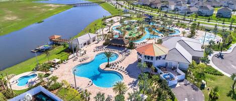 A resort with multiple swimming pools, a dock, and a residential area with houses.