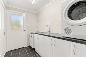 A modern kitchen with a built-in washing machine, a sink, and cabinets.