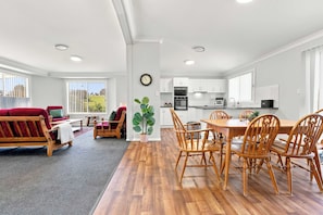 A modern apartment with a living room, dining area, and kitchen.