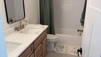 A bathroom with a shower, toilet, and sink.
