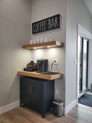 A modern coffee bar area with a sign above, a countertop with coffee-making equipment, and a trash bin. - Modern Coastal 3-bedroom Beach Retreat, Ocean Shores with full kitchen, Fire Pit (Ocean Shores)