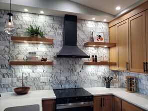 A modern kitchen with marble backsplash, wooden cabinets, and built-in appliances. - Modern Coastal 3-bedroom Beach Retreat, Ocean Shores with full kitchen, Fire Pit (Ocean Shores)