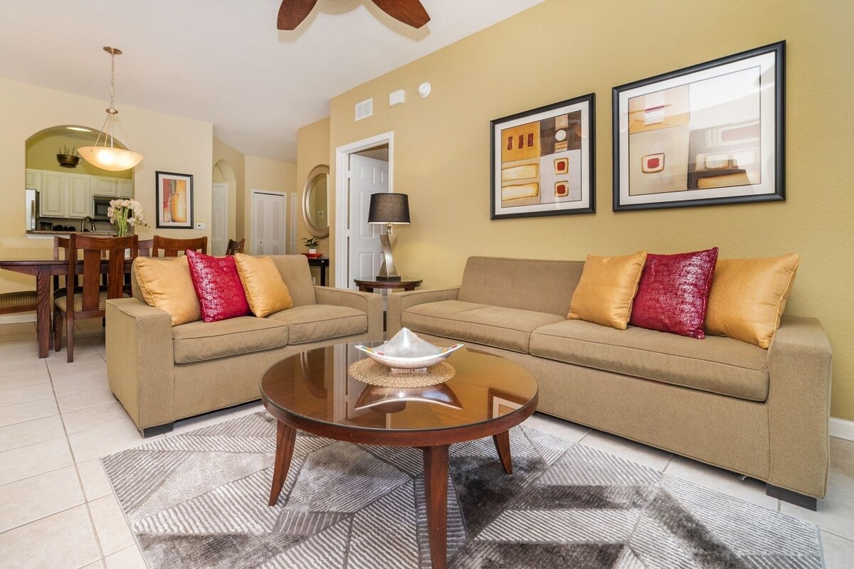 A living room with a sofa, coffee table, and dining area.