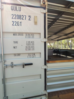 A white shipping container with text detailing its weight and capacity.
