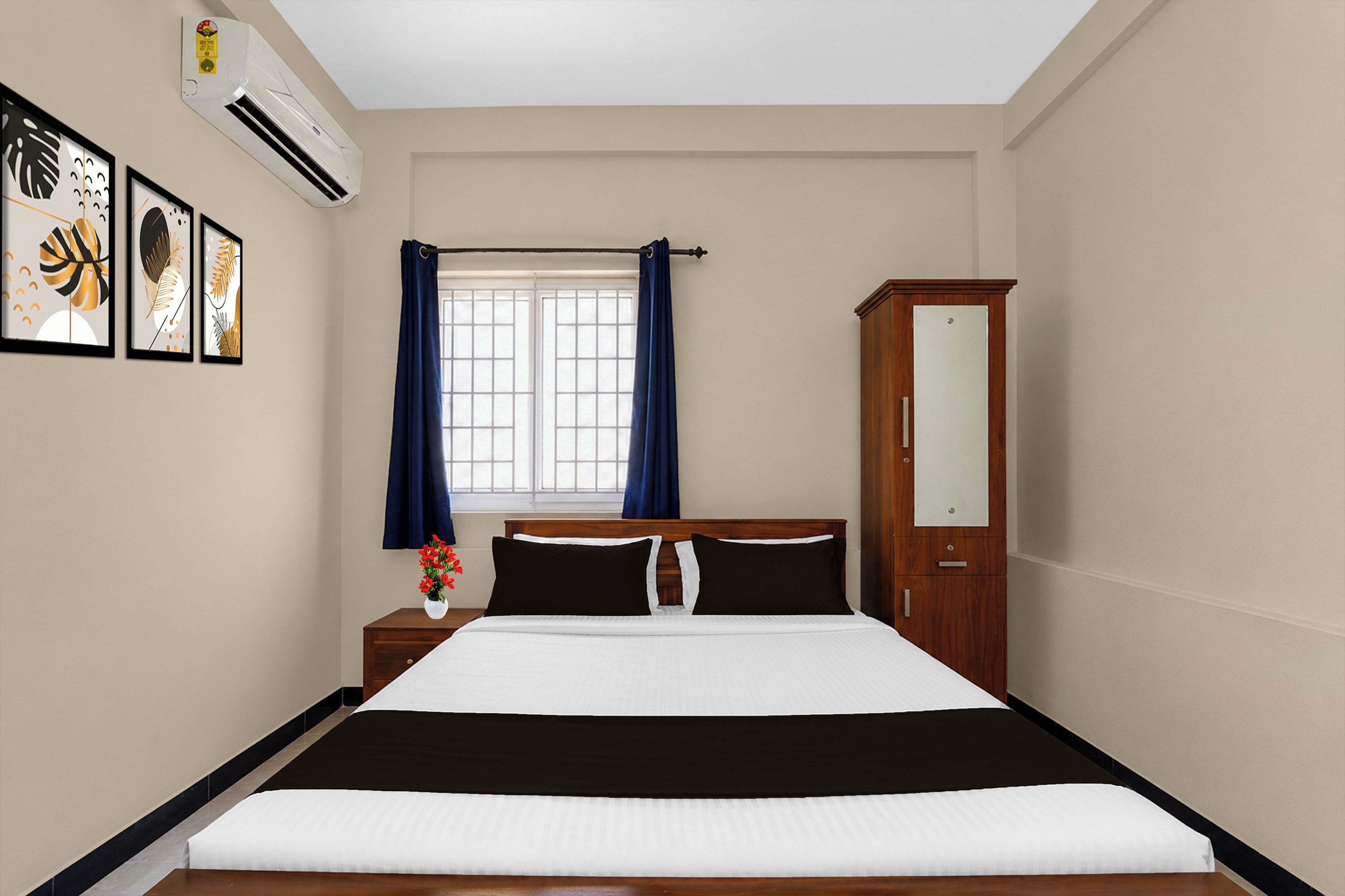 Una habitación de hotel con cama, mesita de noche, cómoda, ventana con cortinas y decoración en la pared.