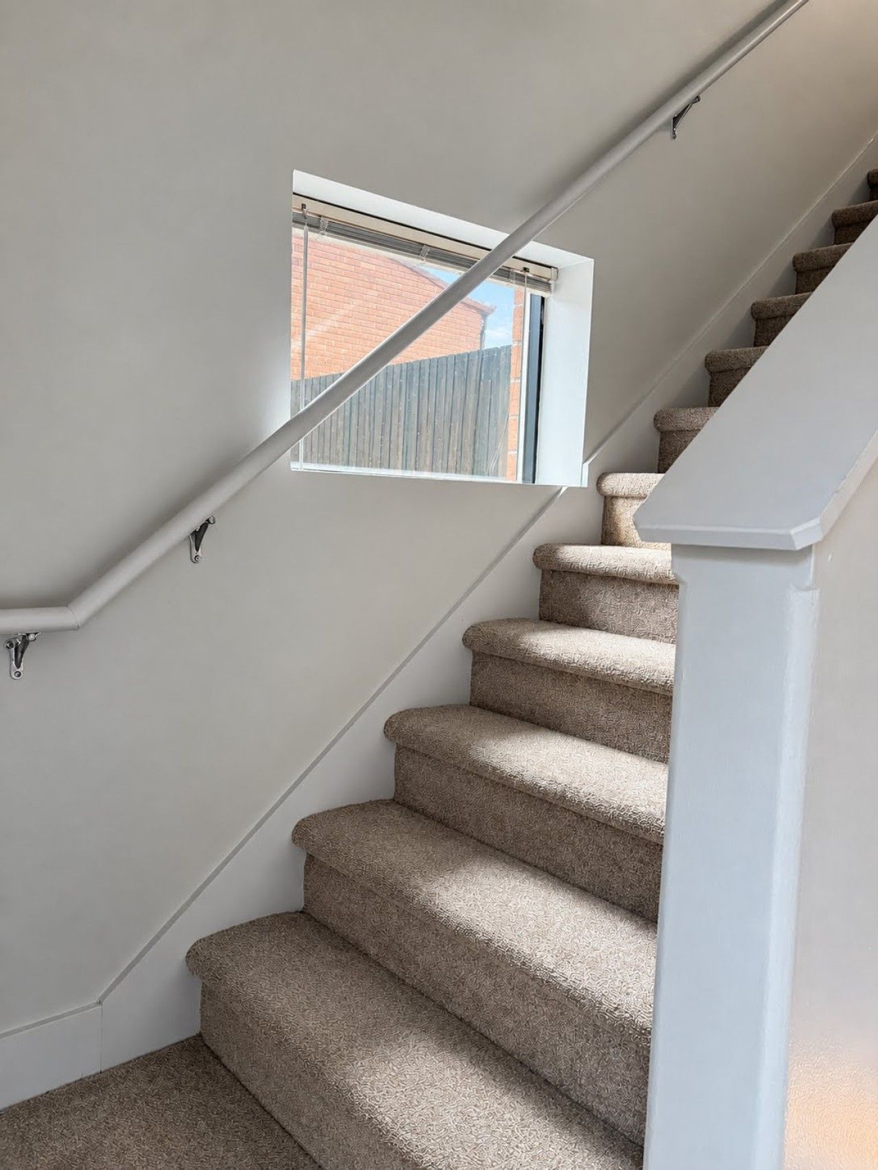 The interior staircase connects the main living area to two bedrooms, a full bathroom, and a cozy den