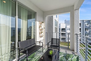 A balcony with a bench, a small table, and potted plants. - Pxc3180-303 2 Bedroom Condo (Kissimmee)