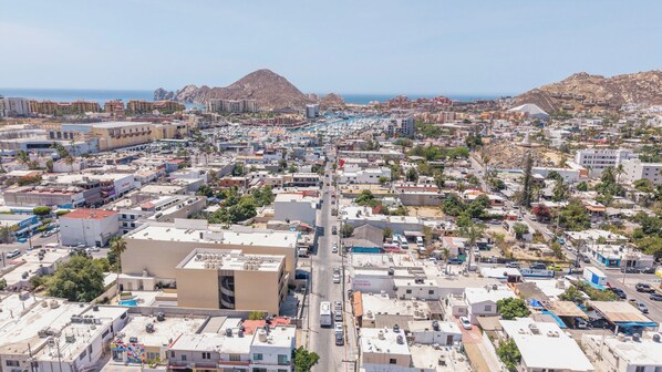 A densely packed urban area with a central road, buildings, and a mountainous backdrop. - Vrbo Property (Cabo San Lucas)