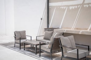An outdoor seating area with a table and chairs, a window, and a wall. - Modern studio 3 blocks from the marina (Cabo San Lucas)