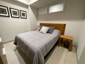A bedroom with a bed, bedside tables, and framed pictures on the wall. - 2BR w/ Rooftop Infinity Pool & Padel Court (Bucerías)
