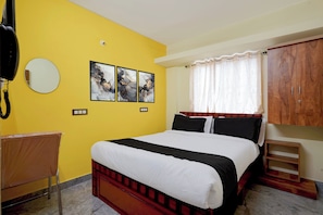 Quarto com cama, guarda-roupa, espelho e obras de arte na parede.