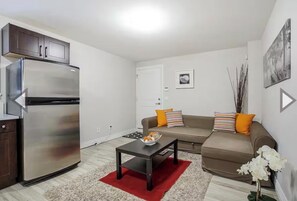 Een ruimtelijke zithoek met een kitchenette, een zithoek en een salontafel.