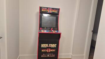Une borne d’arcade rétro, avec le jeu Mortal Kombat II, dans un couloir.