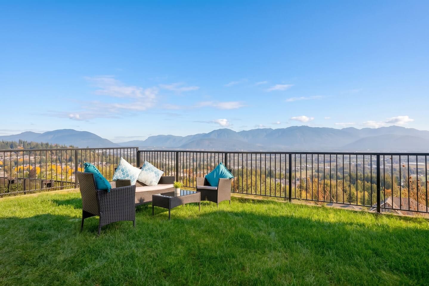 A balcony with wicker furniture and a view of mountains.