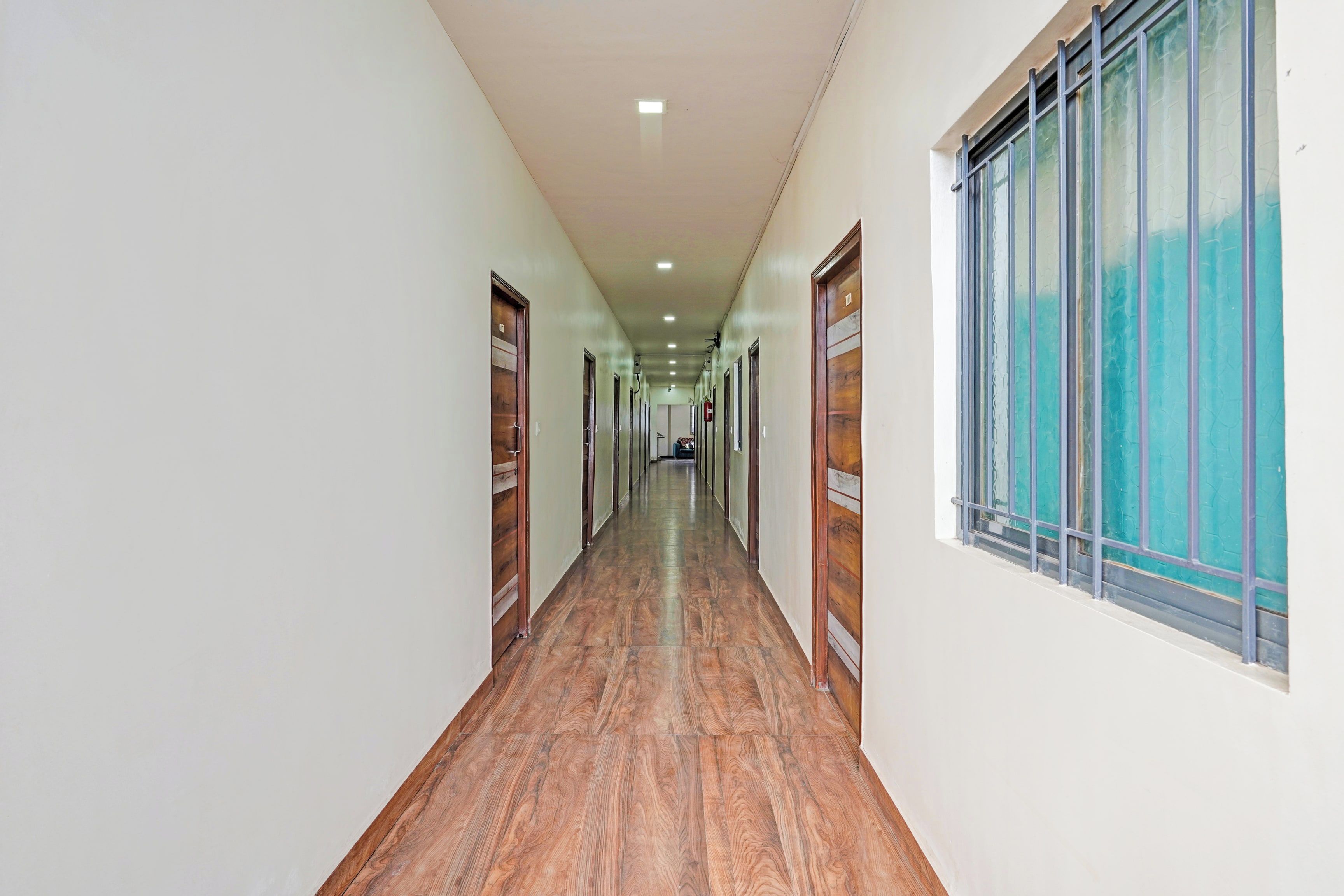 Un long couloir étroit, doté d’un plancher en bois et de portes de chaque côté.