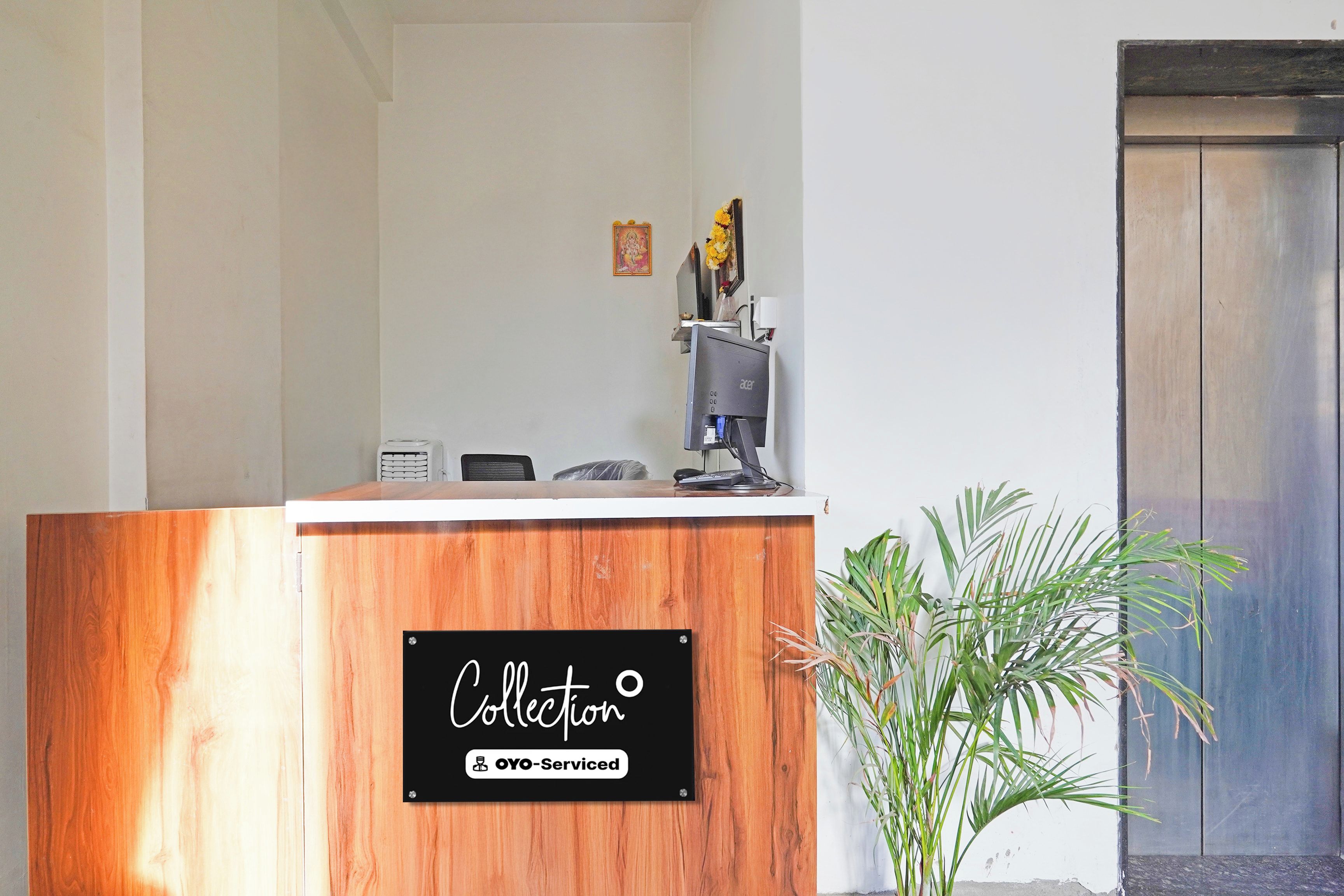 Una reception con finitura in legno e un cartello con scritto 'Collection OYO-Serviced'.