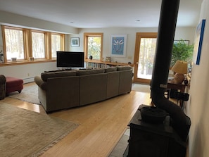 A living room with a large sofa, a television, and a fireplace.