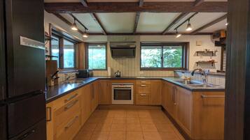A kitchen with wooden cabinets, a built-in oven, a sink, and a window providing natural light.