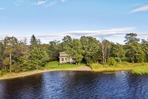 A house by a lake surrounded by trees. - Grand Lake Sunset Haven Relax Unwind Stay (Oakfield)