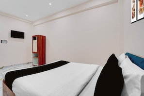 A bedroom with a bed, a wardrobe, a television, and a wall-mounted shelf. - OYO 840189 Vijay Shree Marriage Hall (Gopalganj)