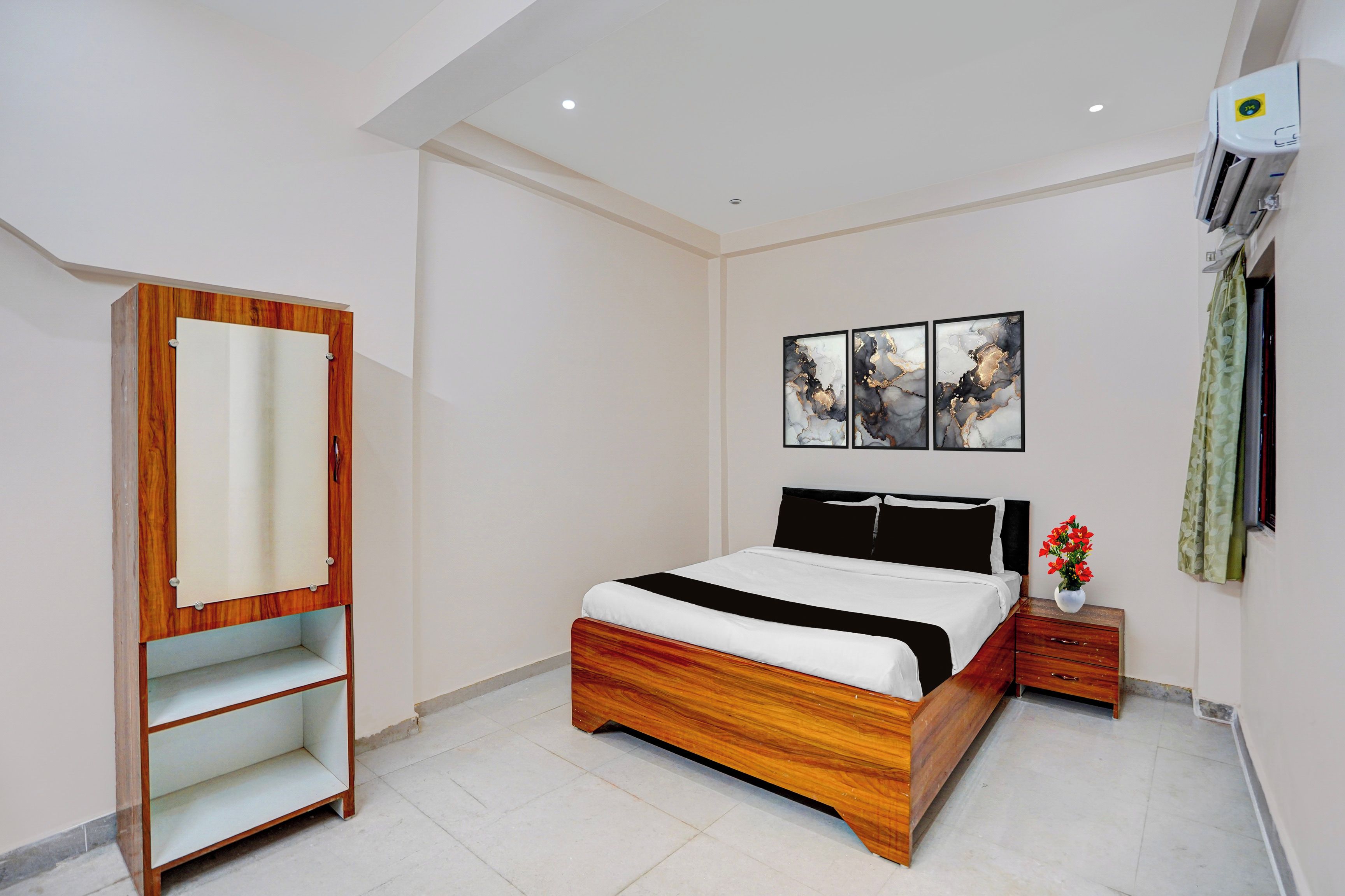 Ein Schlafzimmer mit Bett, Kleiderschrank, Nachttisch und Wandbildern.
