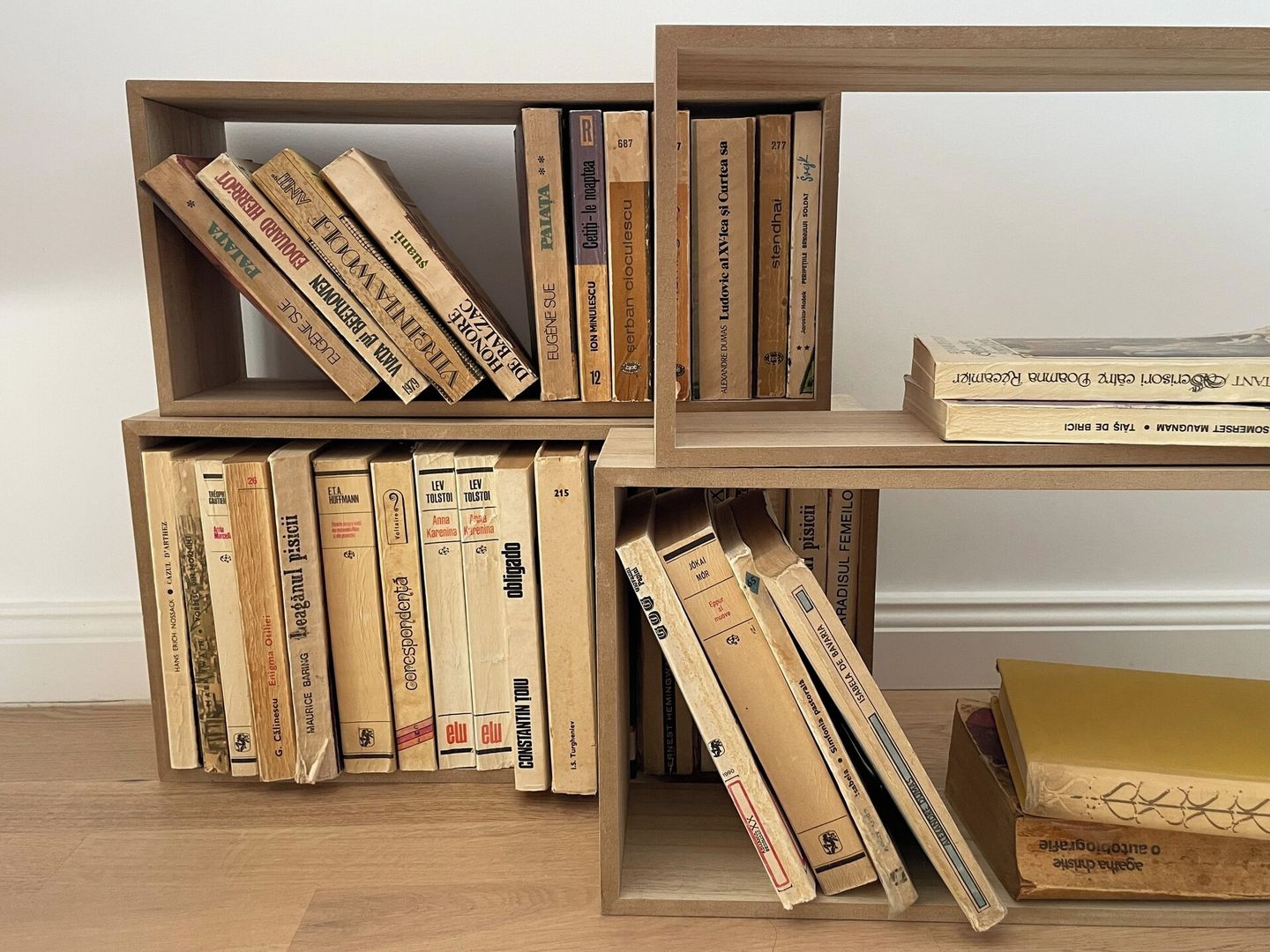Ein Bücherregal mit mehreren Holzböden, voll mit Büchern.