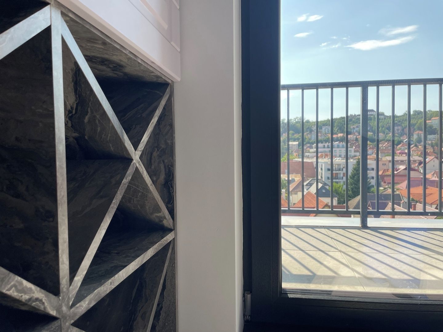 Ein Zimmer mit Balkon und Blick auf eine Stadt.