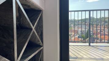 Ein Zimmer mit Balkon und Blick auf eine Stadt.