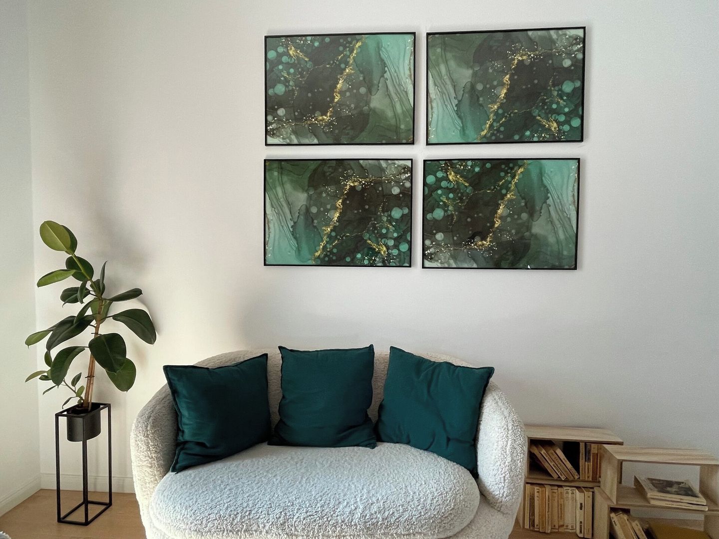 Una habitación con un sofá blanco con textura, cojines verde azulado y una planta en un soporte negro.