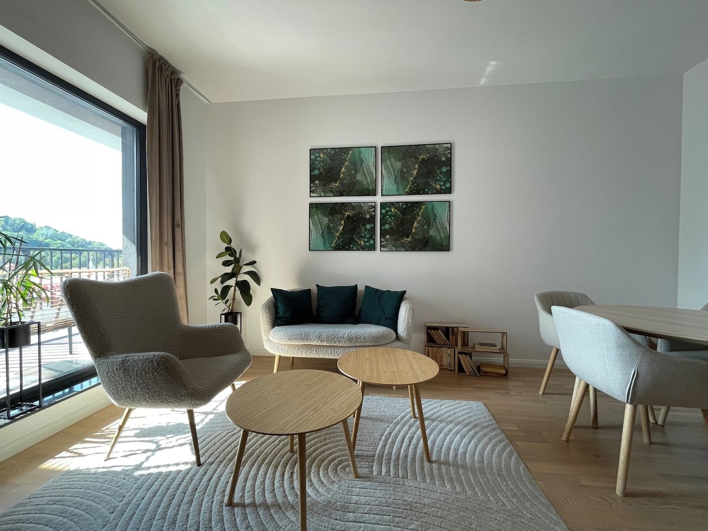 A modern living room with a sofa, two round tables, a chair, and a bookshelf.