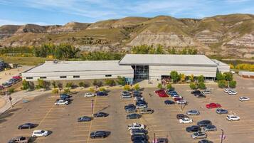 A large parking lot with multiple cars and a building with a flat roof in the background.